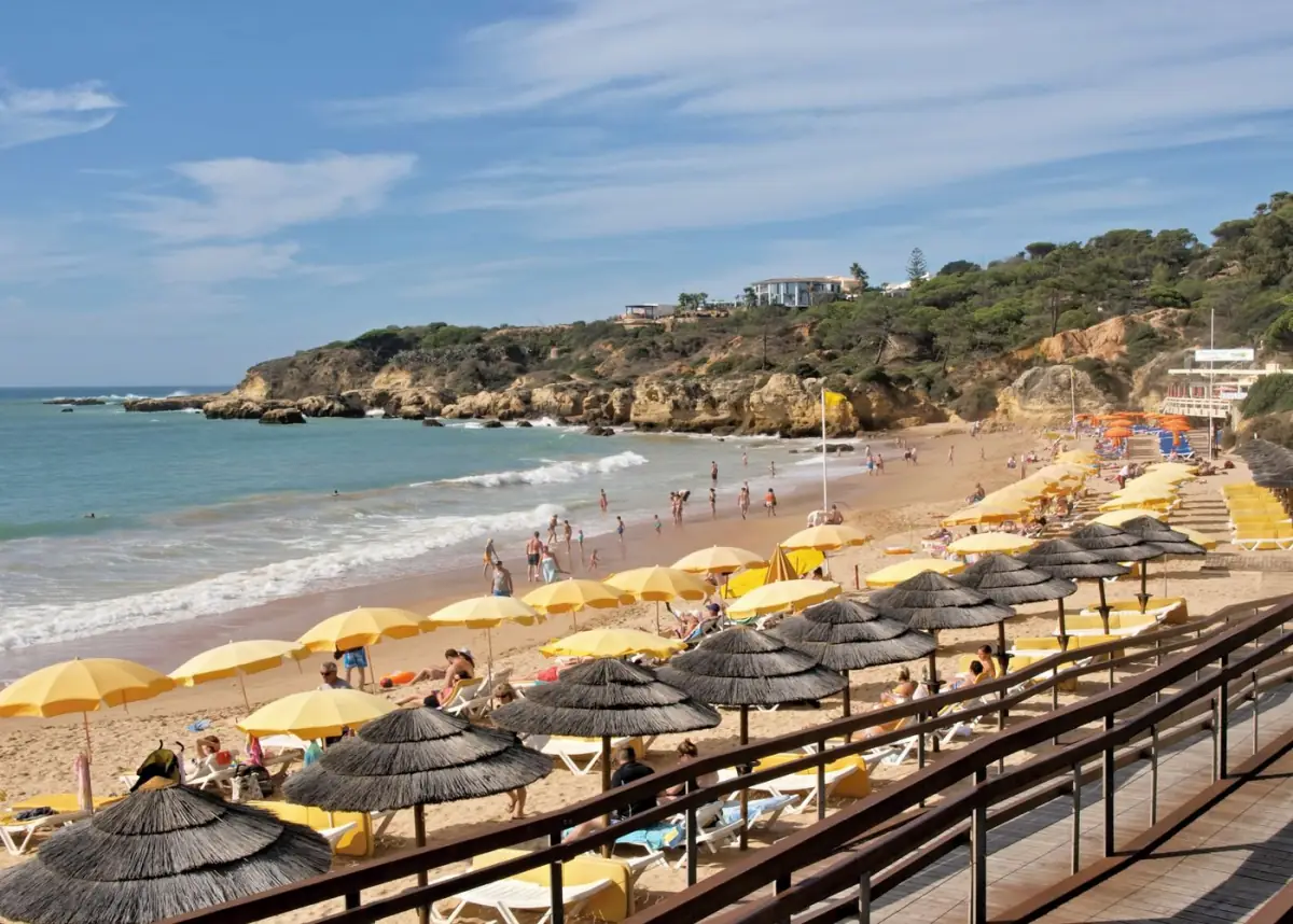 Praia de Albufeira com guarda-sóis e banhistas num dia de verão