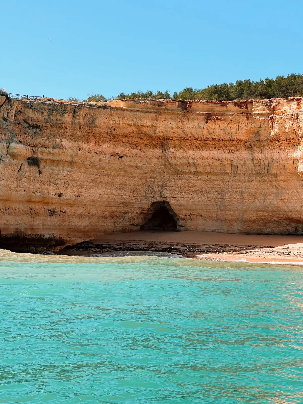Gruta marinha de Benagil com águas turquesa e céu azul vista por dentro