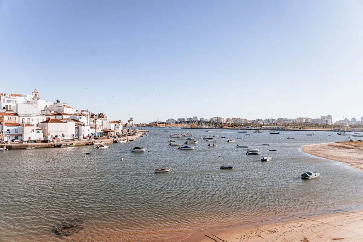 Frente ribeirinha de Portimão com barcos atracados e casas brancas