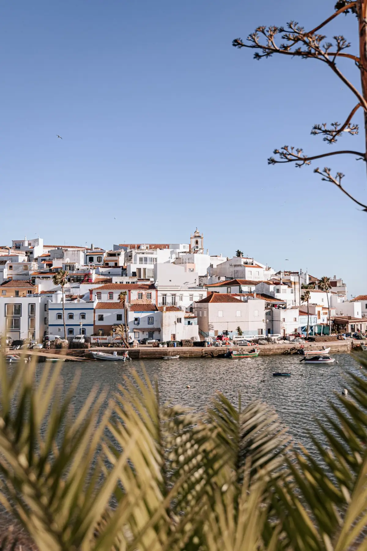 Frente ribeirinha de Ferragudo com barcos de pesca e casas brancas junto ao rio Arade