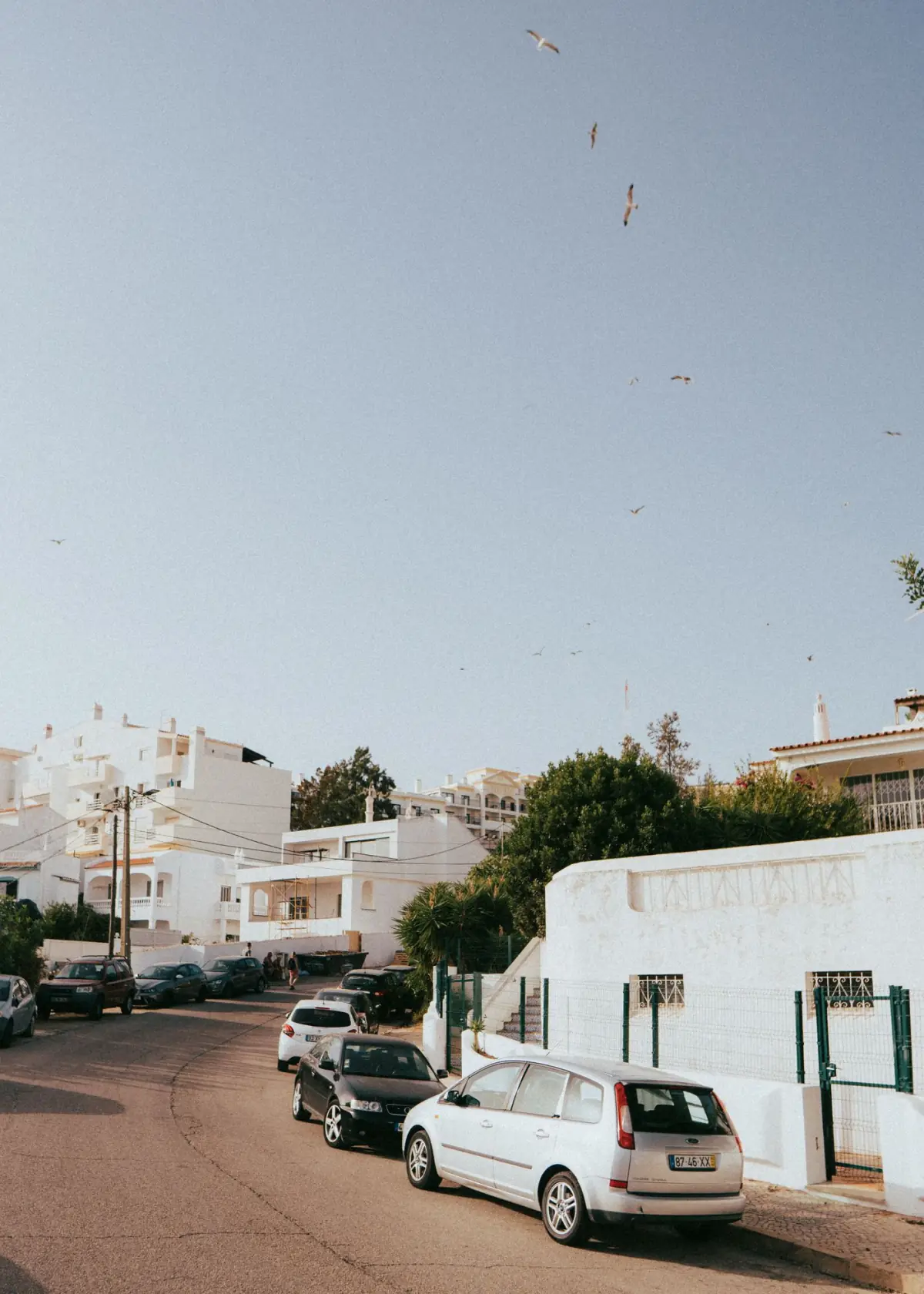 Rua de casas brancas tradicionais numa vila do Algarve ao sol