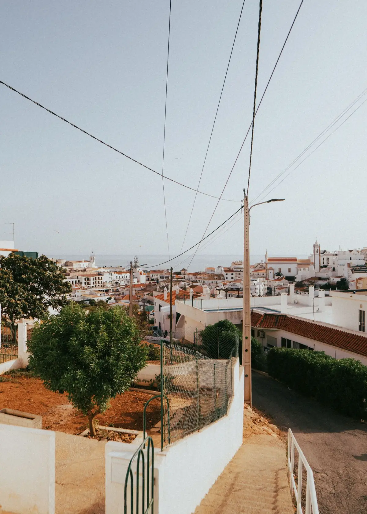 Telhados brancos e ruas estreitas de uma vila tradicional do Algarve ao sol