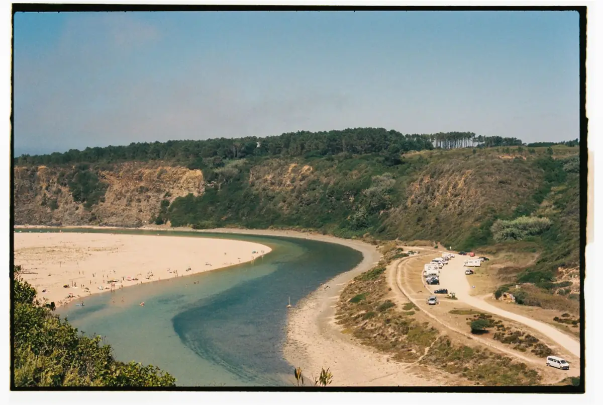 Praia de Odeceixe-Mar com o rio Seixe a correr paralelo ao oceano entre falésias da Costa Vicentina