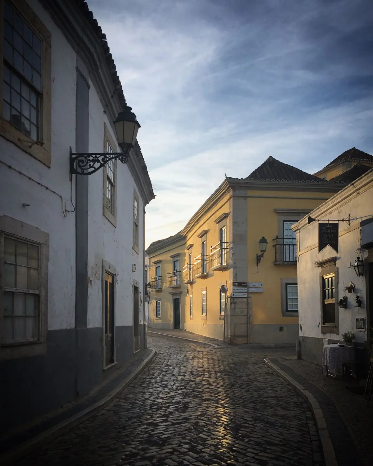 Ruela de calçada com edifícios tradicionais numa vila do Algarve