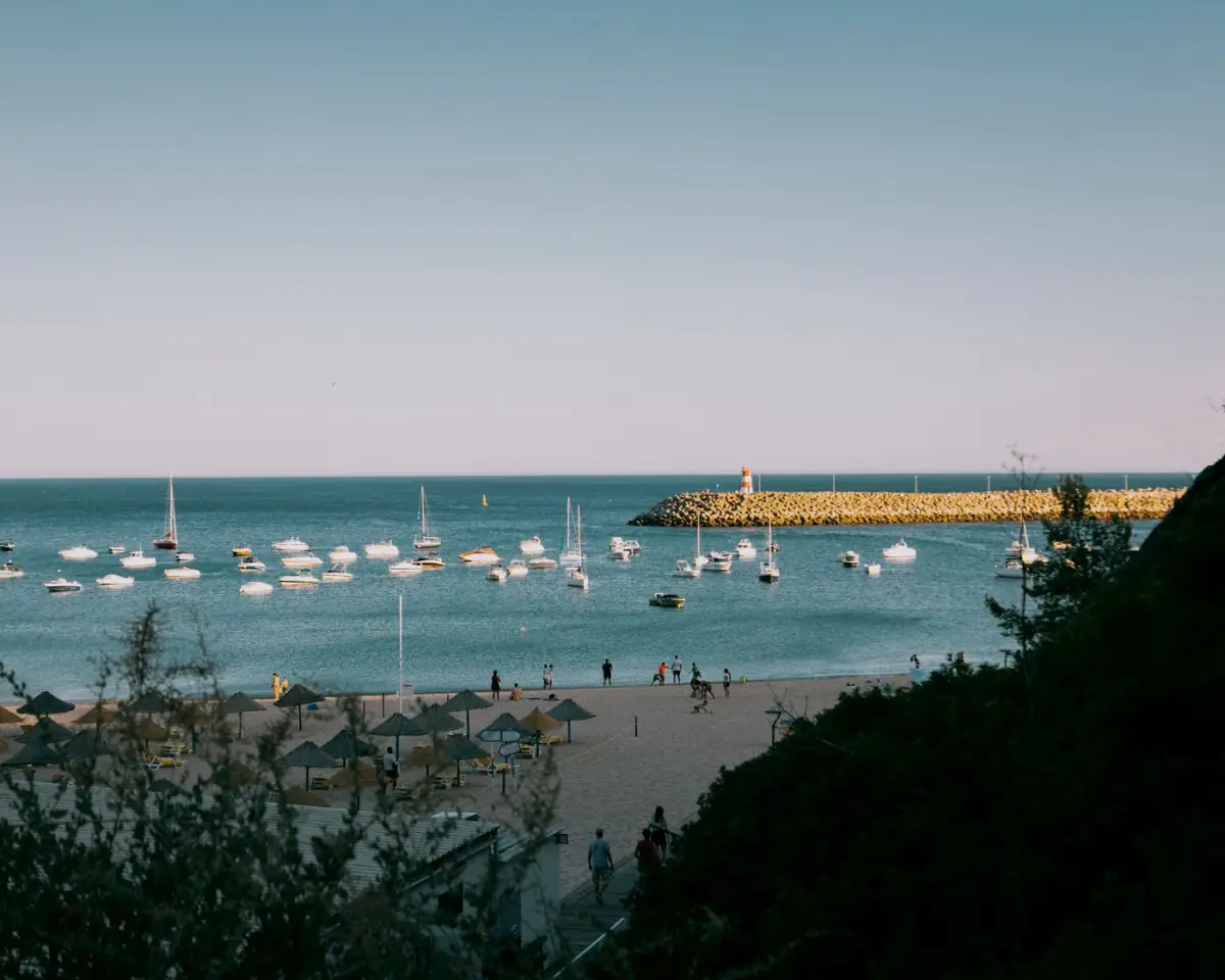Praia tranquila perto de Vilamoura com pequenos barcos ancorados junto à areia dourada