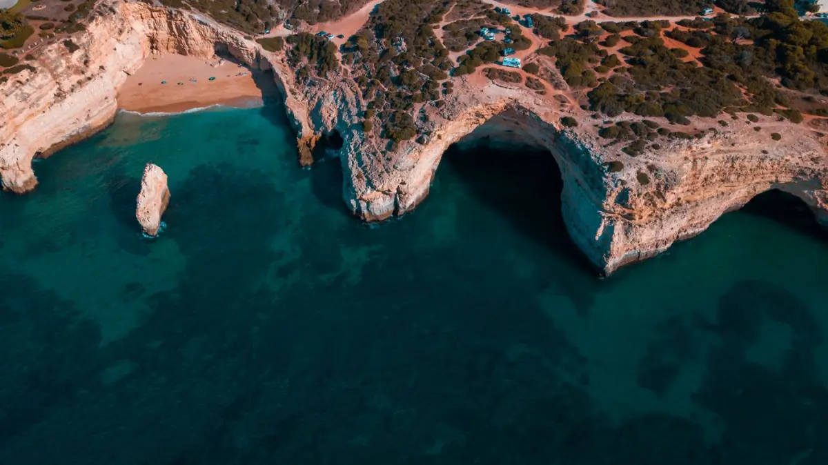 Vista aérea das falésias douradas e da pequena enseada da Praia do Carvalho, perto de Carvoeiro