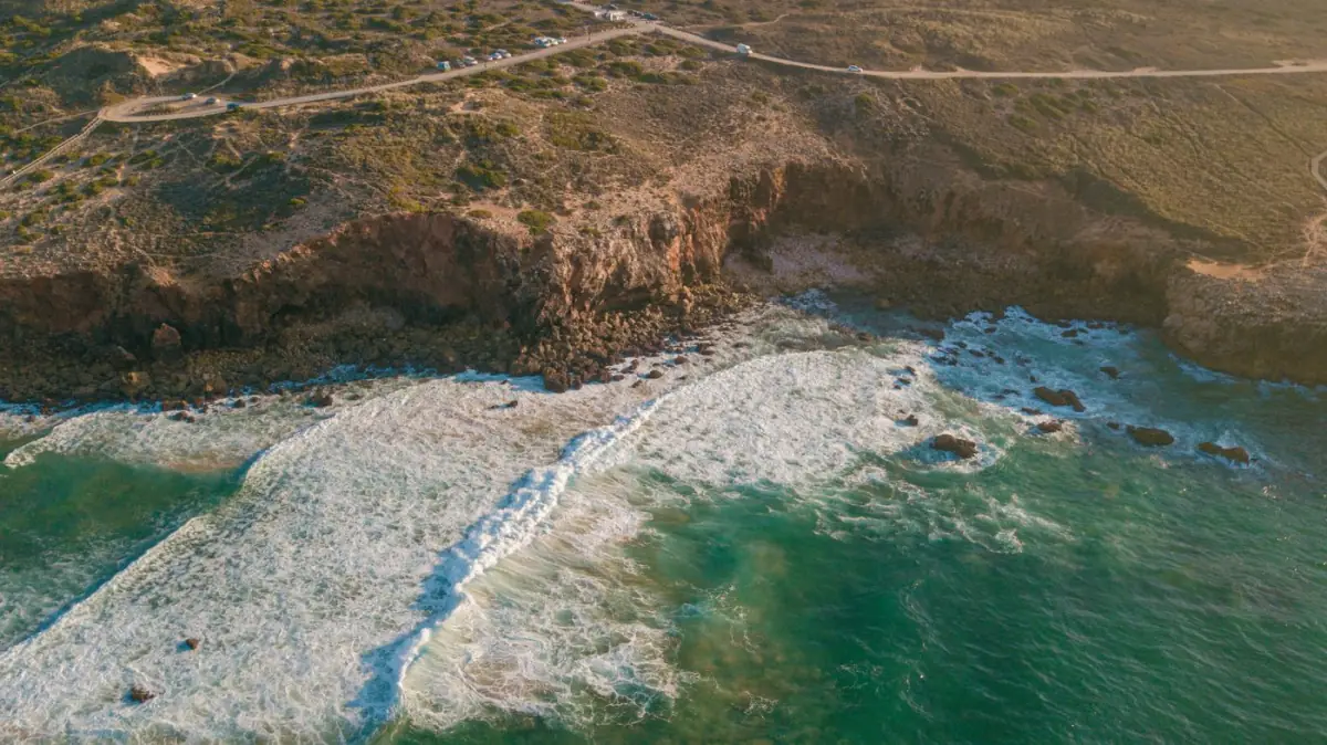 Ondas a rebentar contra uma falésia na costa oeste do Algarve