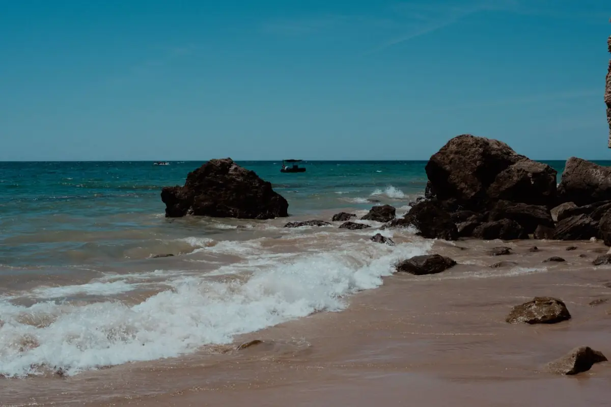 Praia rochosa do Atlântico no Barlavento algarvio com falésias e mar azul