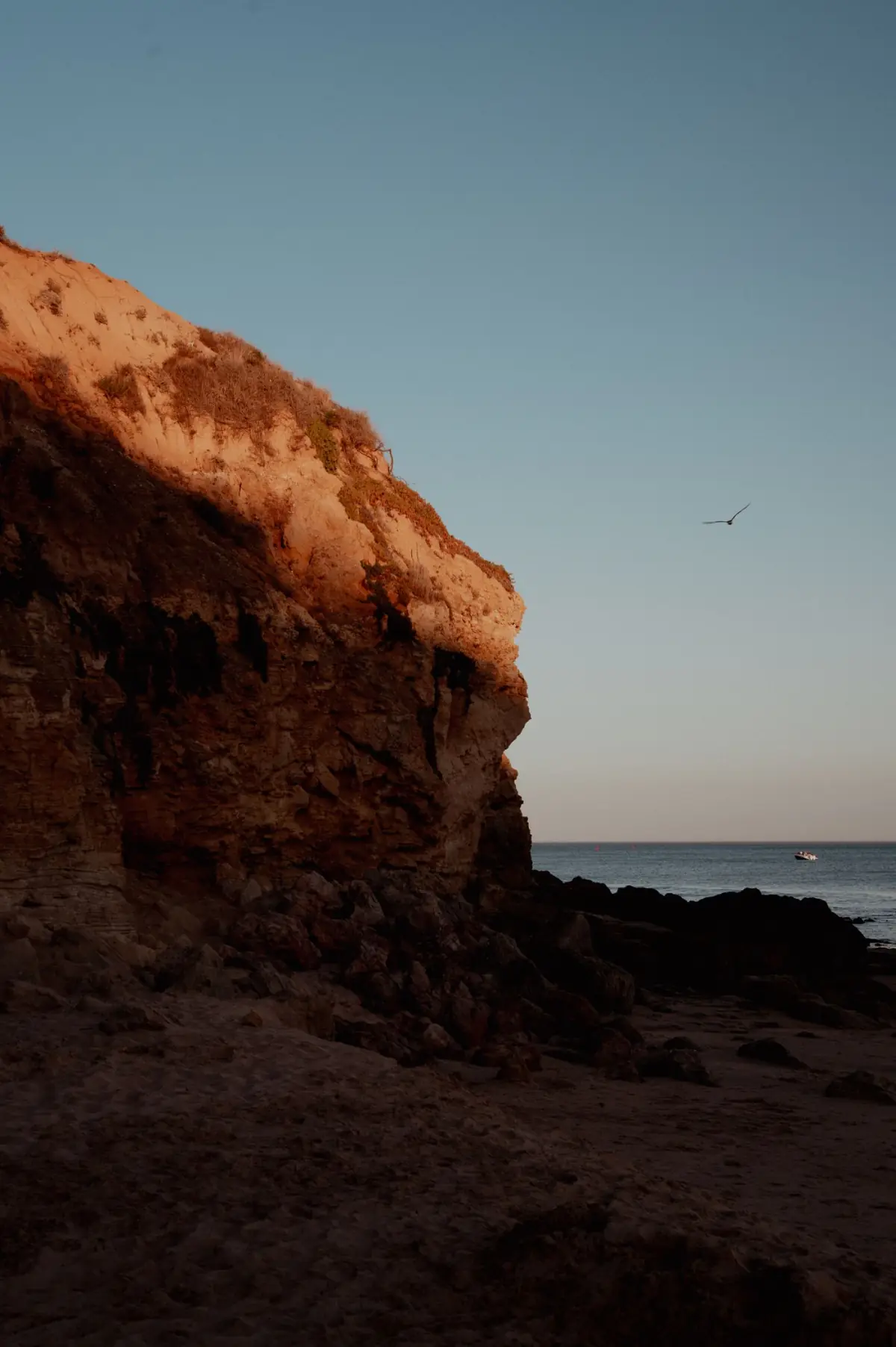 Falésias e oceano de Albufeira a ganhar tons quentes ao pôr do sol