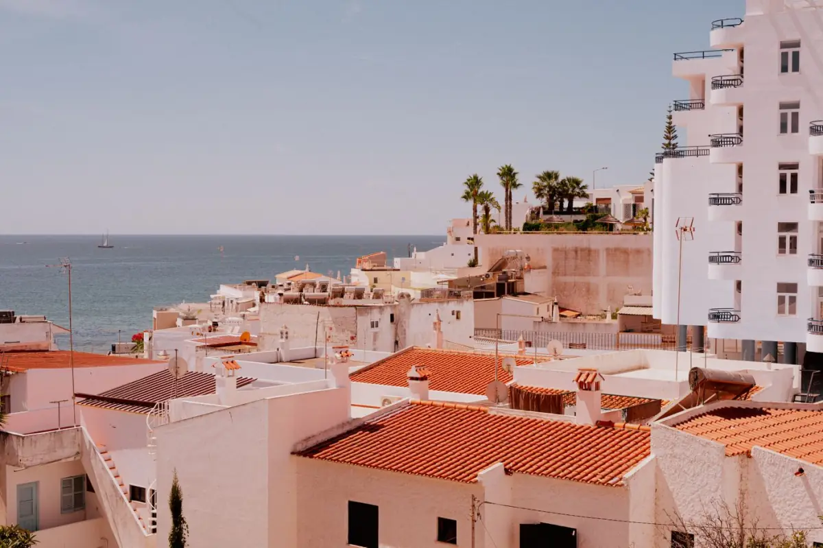 Casas mediterrânicas à beira-mar no Algarve com telhados de telha, típicas do aluguer de férias