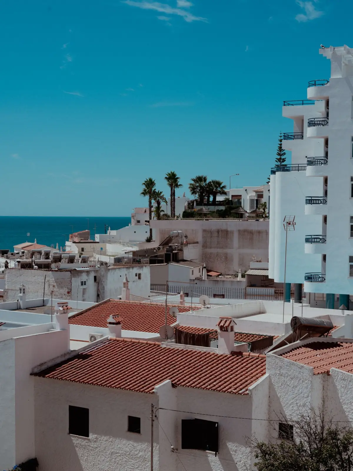 Aldeia costeira do Algarve com arquitetura mediterrânica de casas brancas e ruas estreitas ao final da tarde