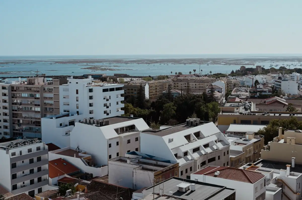 Paisagem urbana de Faro debruçada sobre o Atlântico, com a cidade e a Ria Formosa