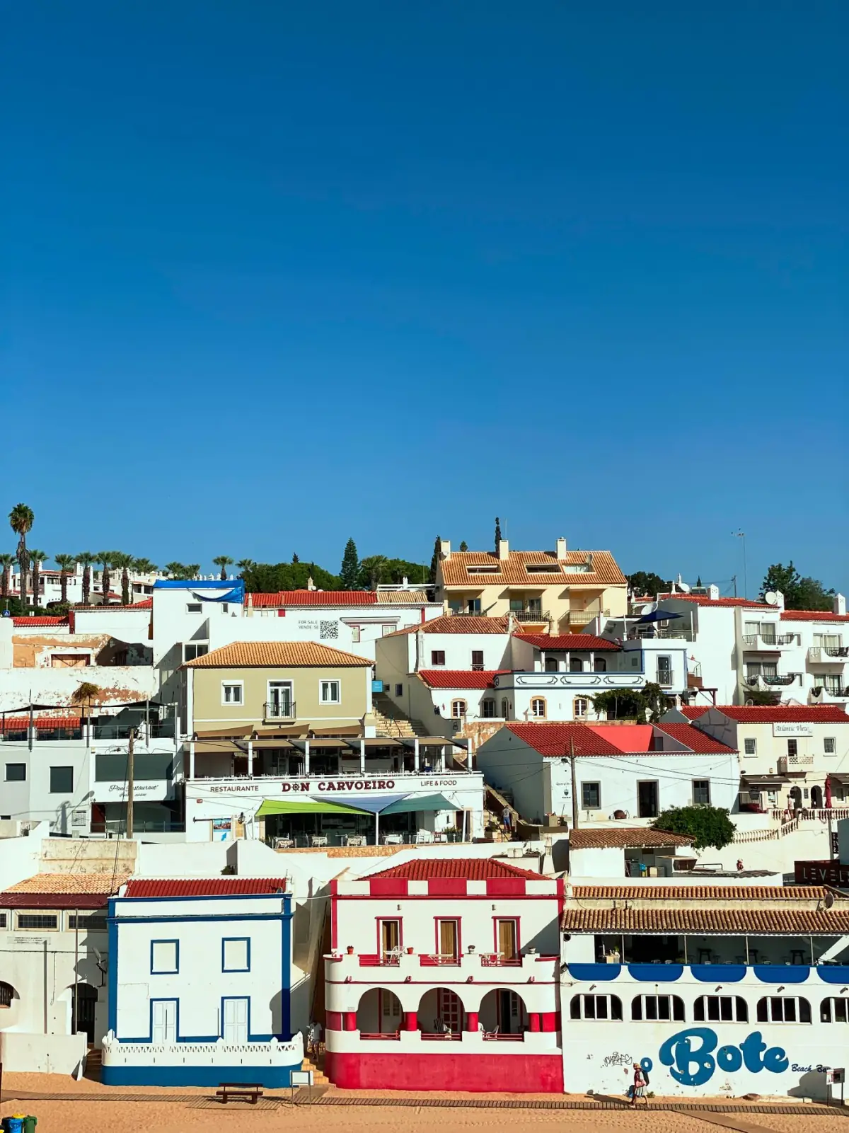 Casas costeiras de Carvoeiro sob céu de verão no Algarve