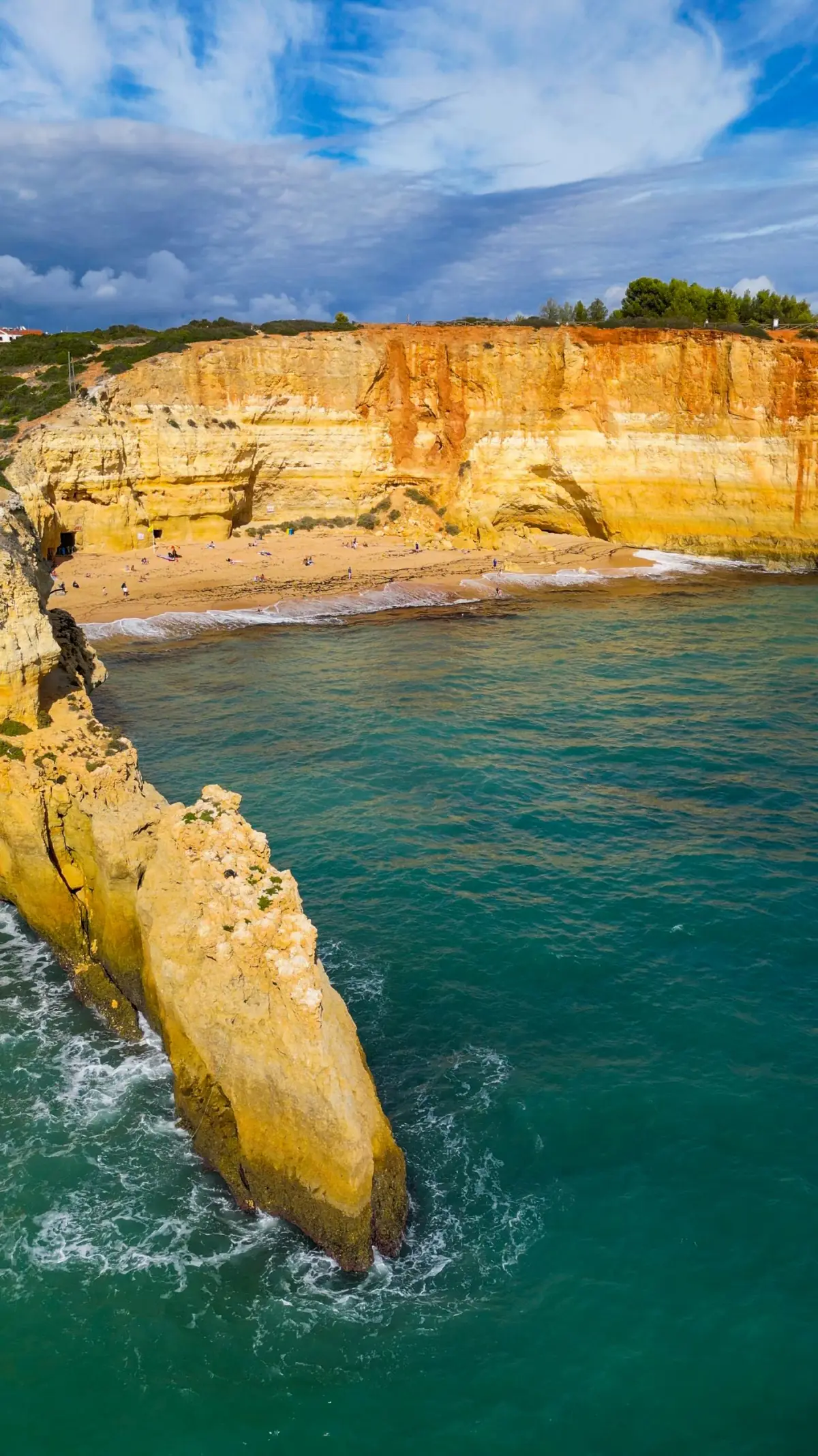 Falésias douradas e areia da praia de Benagil, junto à famosa gruta, em Lagoa