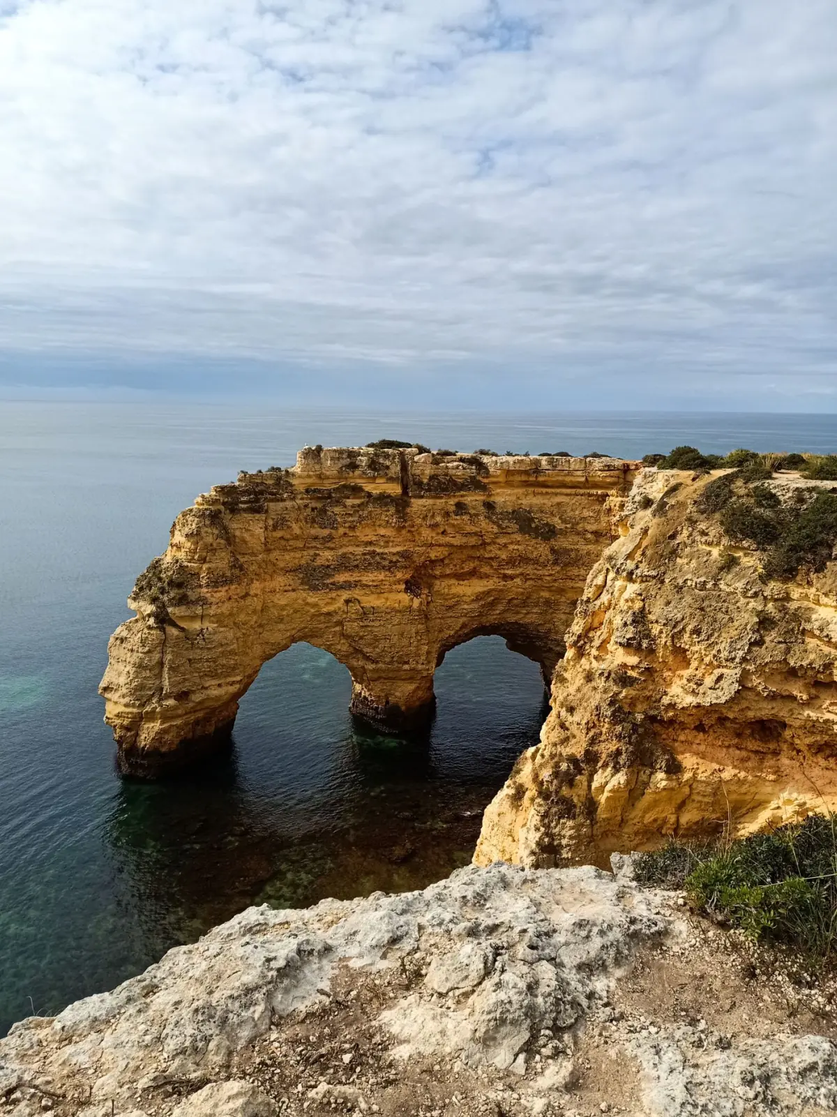 Arcos rochosos naturais gémeos na Praia da Marinha sobre água azul-turquesa