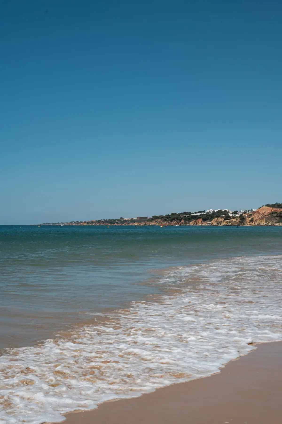 Ondas calmas numa praia algarvia em dia de sol fora de época, sem multidões