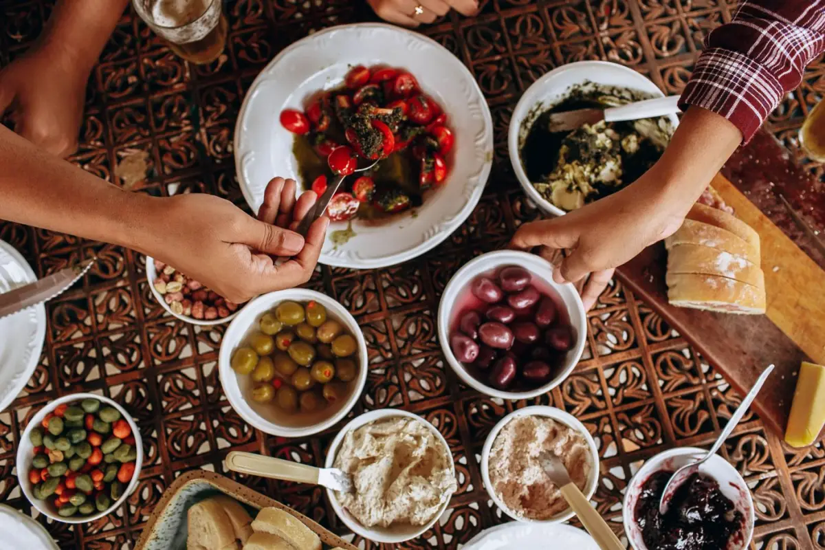 Mesa algarvia com peixe, azeitonas, pão e pratos de marisco ao sol