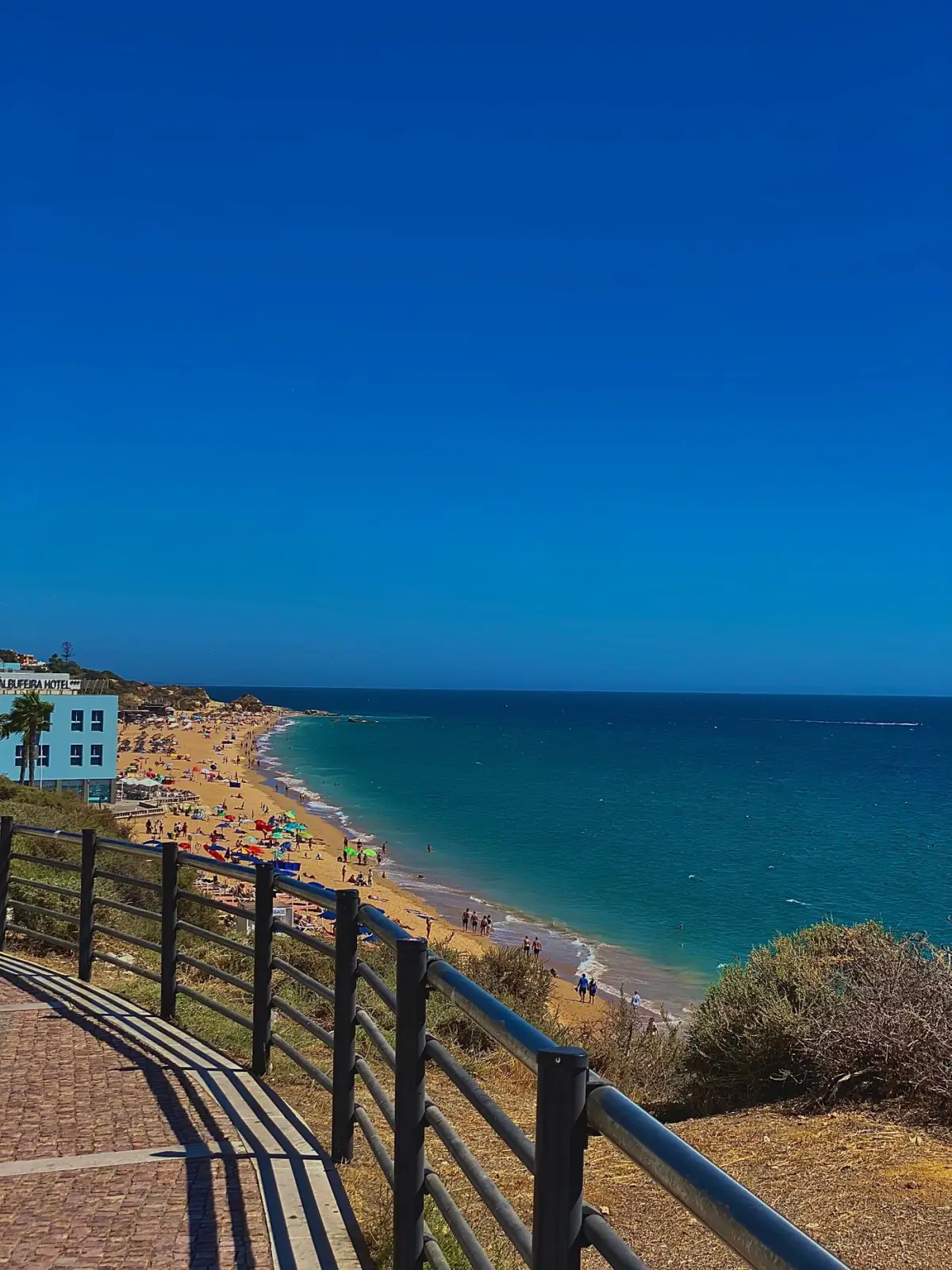 Praia de areia dourada e mar limpo e calmo num dia de sol no Algarve