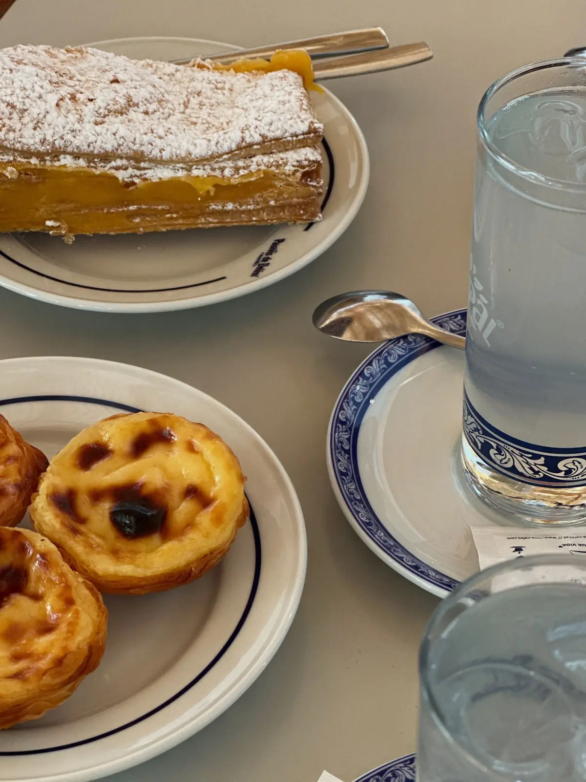 Doces tradicionais portugueses servidos com uma bebida sobre a mesa de uma casa