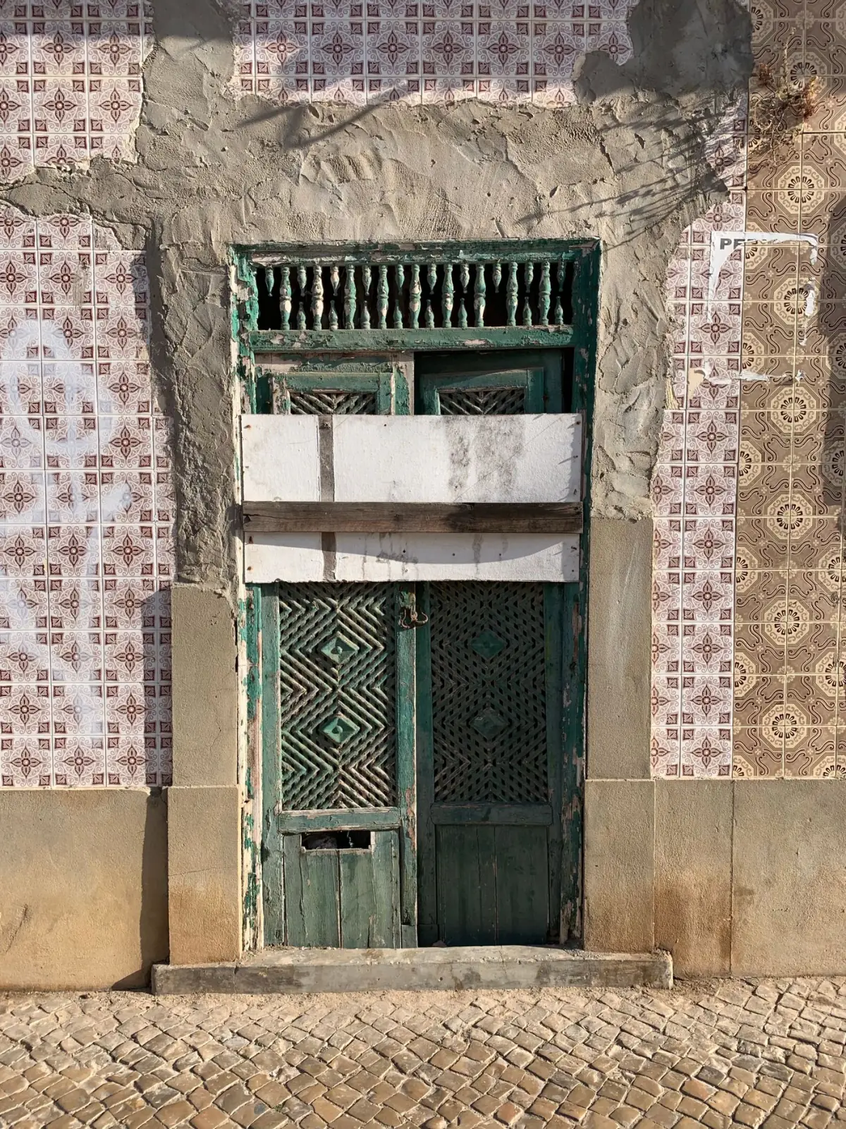Porta tradicional verde com azulejos decorativos numa casa do centro histórico de Tavira