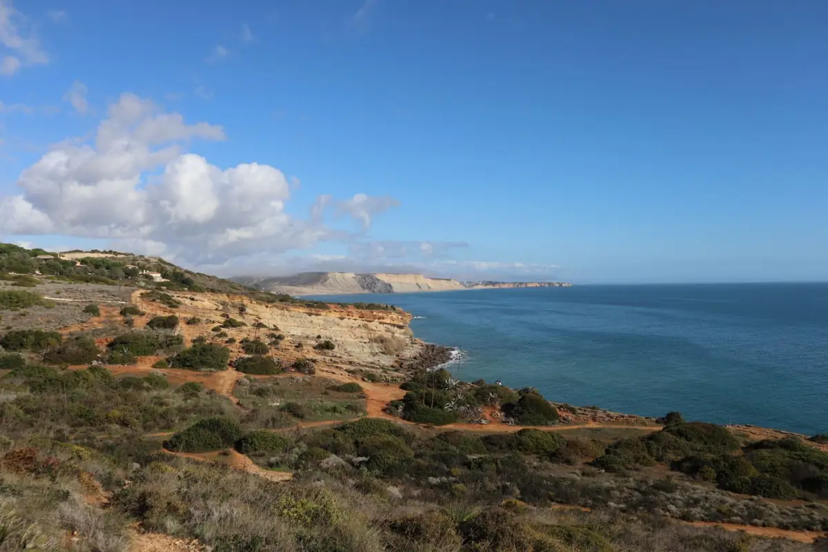 Falésias costeiras do Algarve sob céu azul a oeste de Lagos