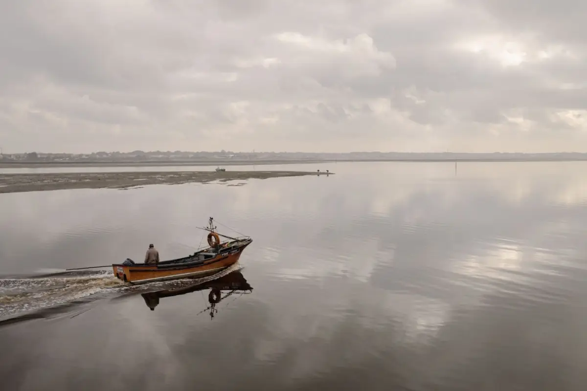 Barco solitário em águas calmas da Ria Formosa entre as ilhas-barreira do Sotavento