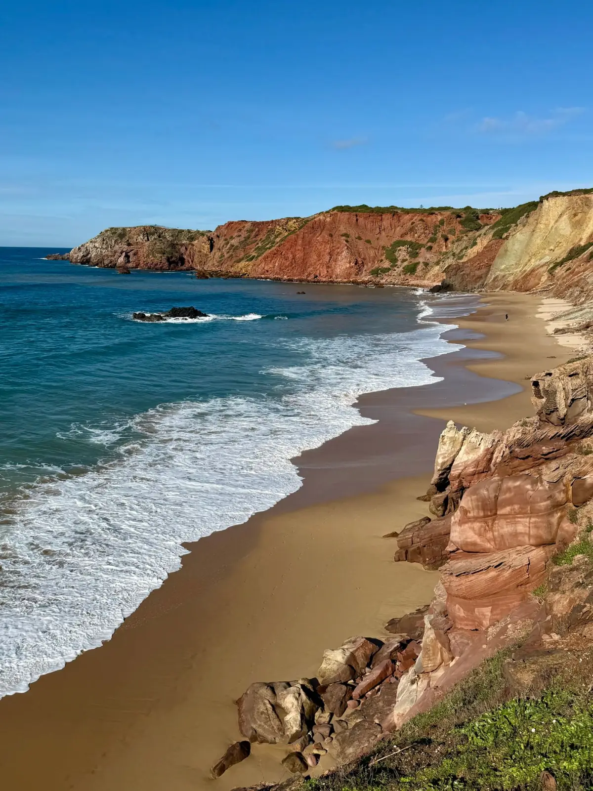 Falésias vermelhas e ocre da Praia da Falésia junto ao areal e ao Atlântico, no Centro do Algarve