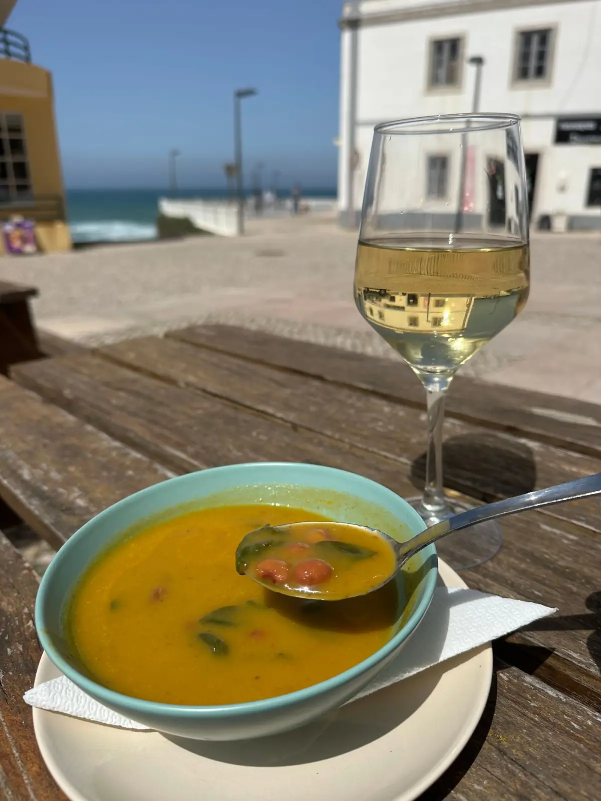 Sopa de marisco e copo de vinho branco numa esplanada à beira-mar no Sotavento do Algarve