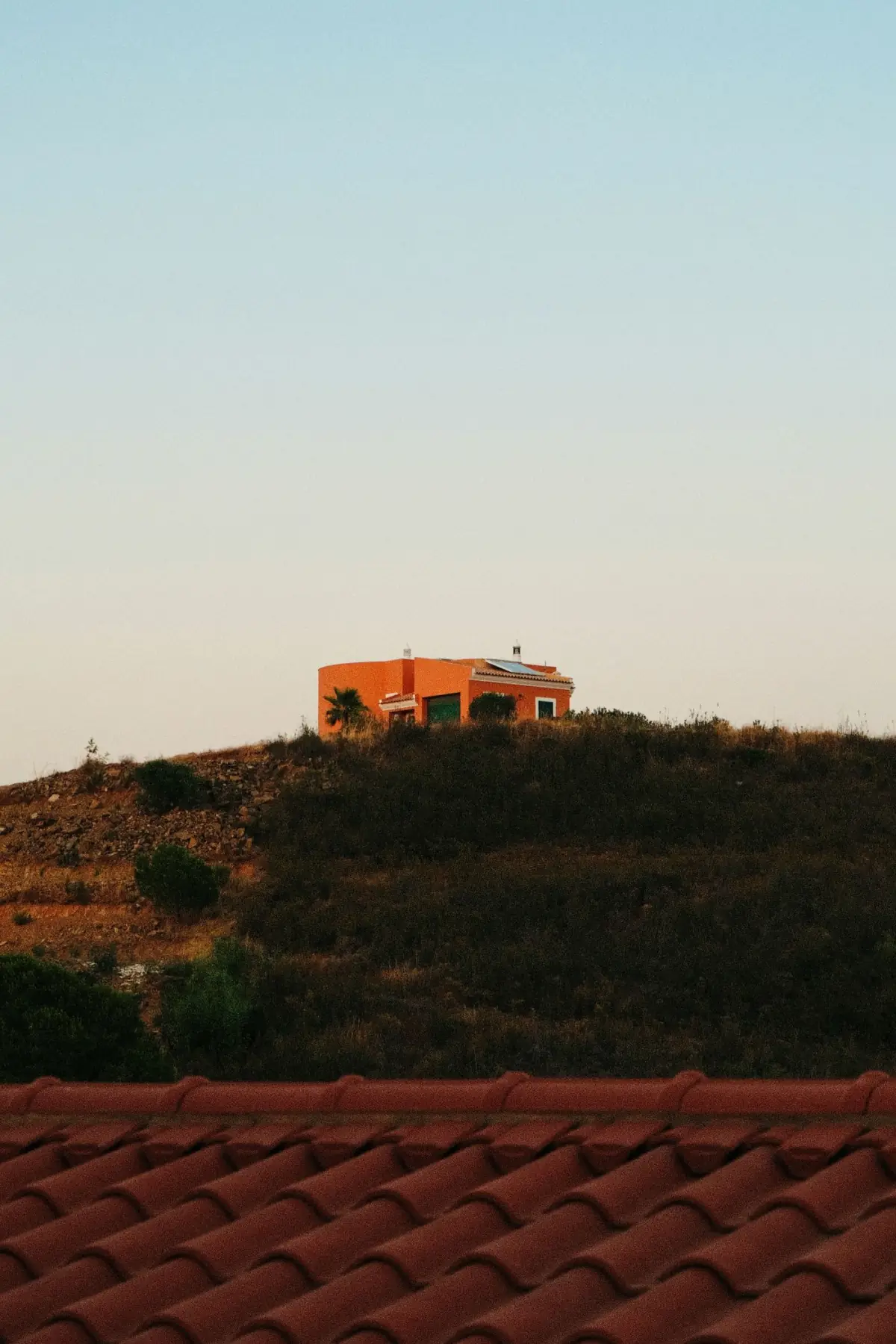 Casario da colina de Tavira ao pôr do sol, com a Ria Formosa ao fundo