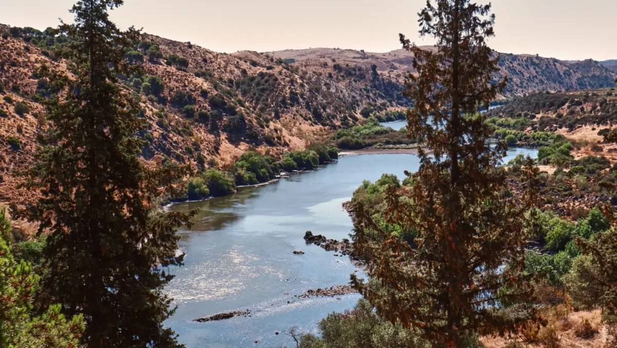 O rio Guadiana a serpentear entre colinas verdes na fronteira entre Portugal e Espanha junto a Vila Real de Santo António