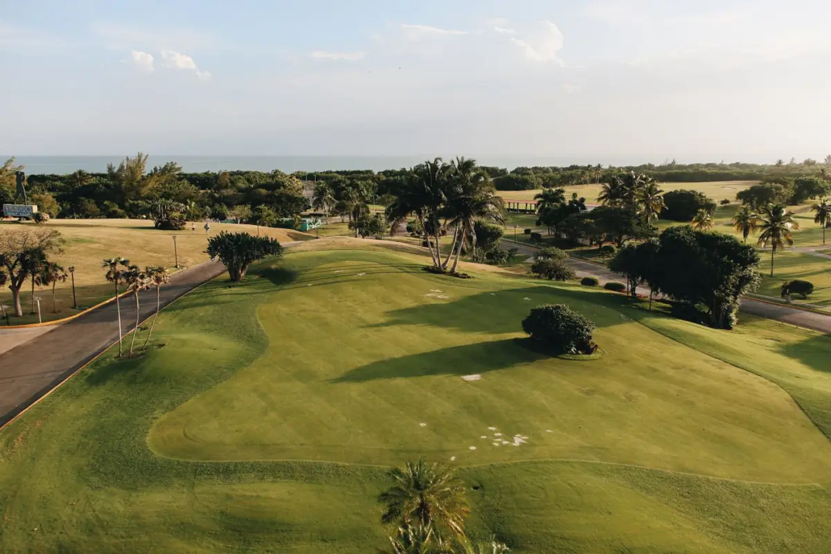 Campo de golfe em Vilamoura com fairways verdes, palmeiras e o mar ao fundo