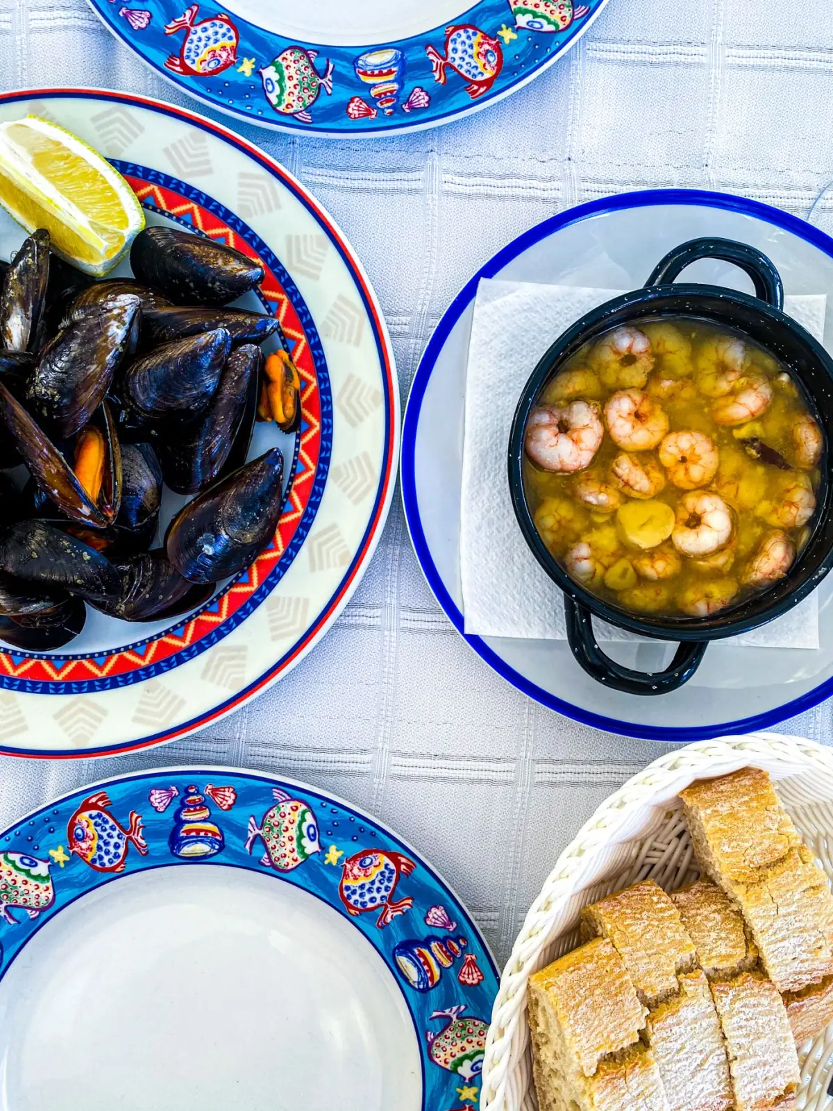 Mexilhões e camarões servidos em pratos decorativos, marisco típico de uma cataplana algarvia