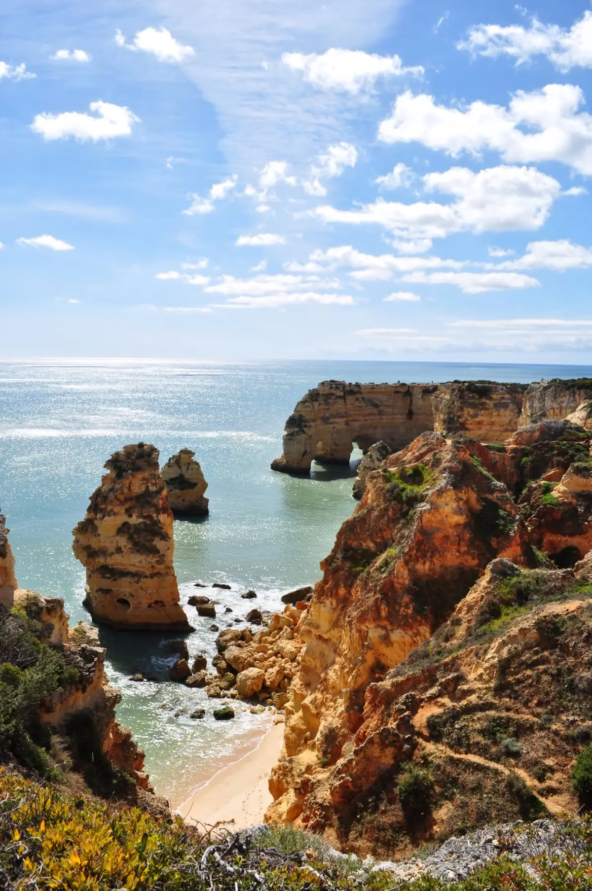 Formações rochosas e arcos de pedra ao longo da costa de Lagos sobre o mar azul
