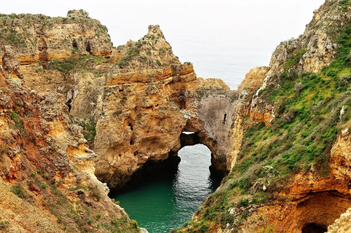 Arco rochoso natural sobre o mar na costa de Lagos, no Barlavento do Algarve