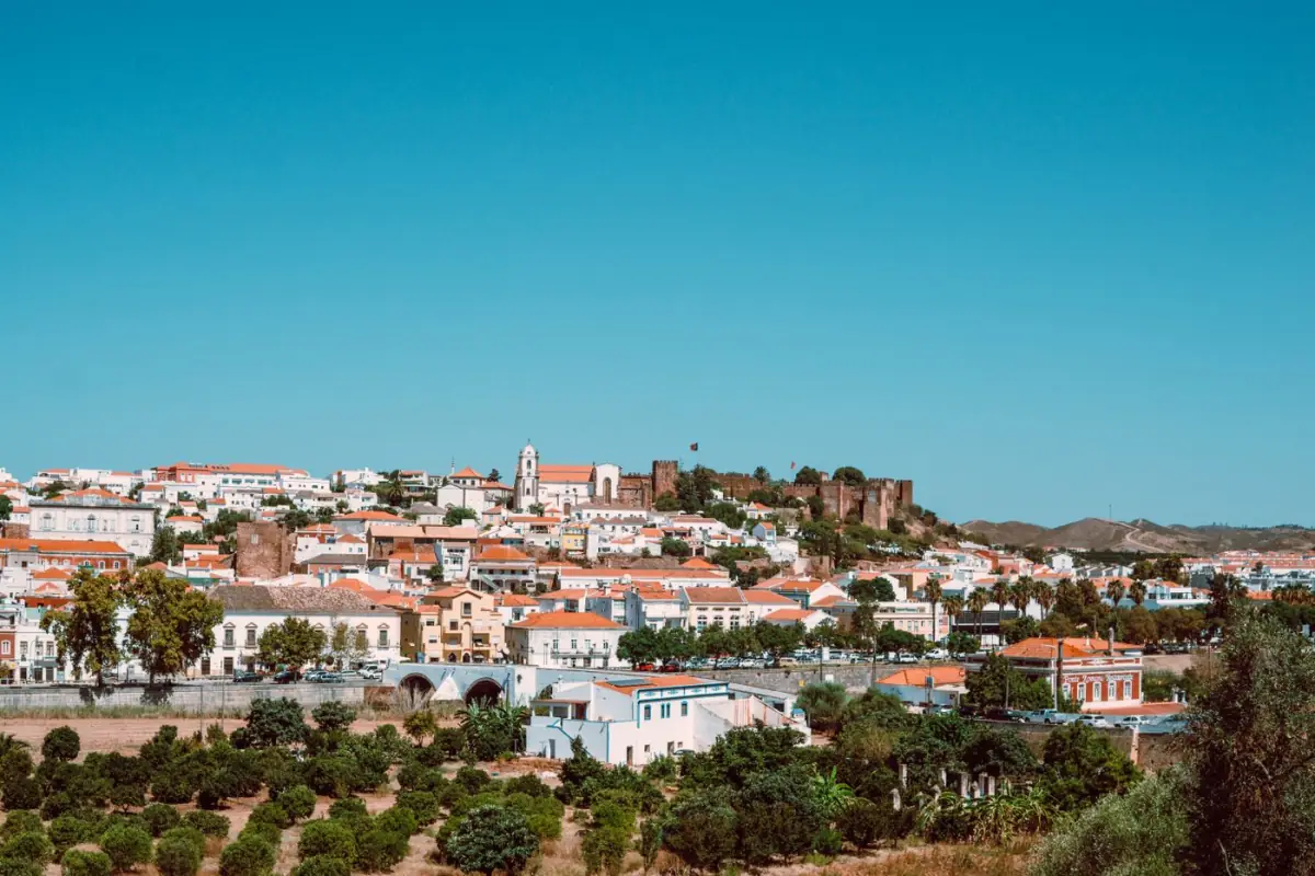 Vista panorâmica de Silves com o castelo de muralhas vermelhas sobre a vila e o casario branco