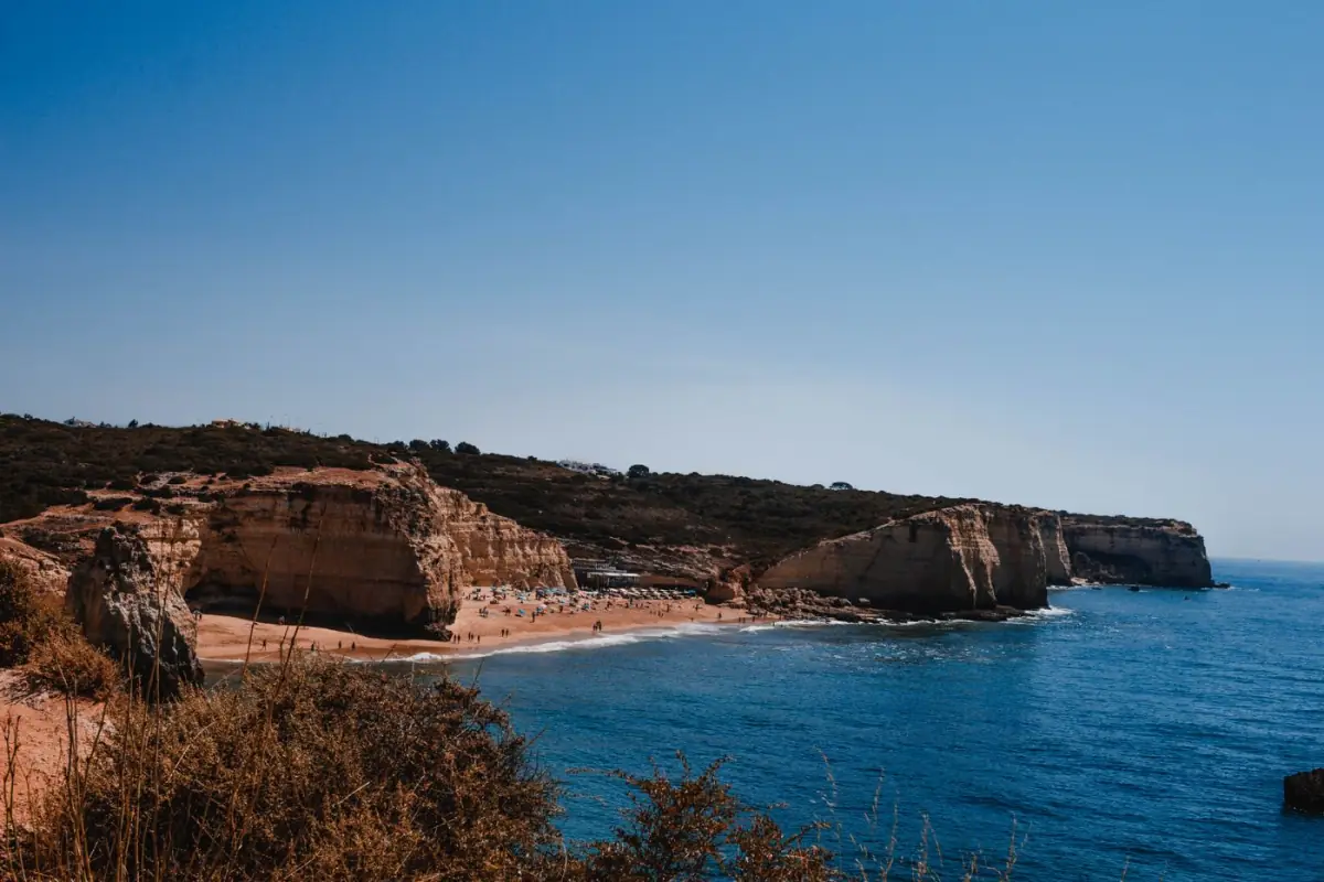 Falésias douradas e mar calmo na praia de Carvoeiro no Algarve central