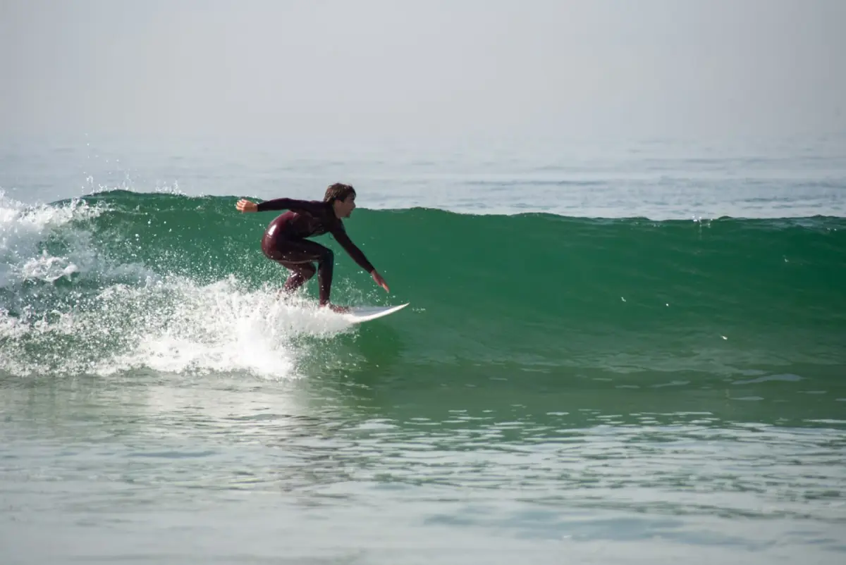 Surfista a deslizar numa onda na Praia do Amado, no oeste do Algarve