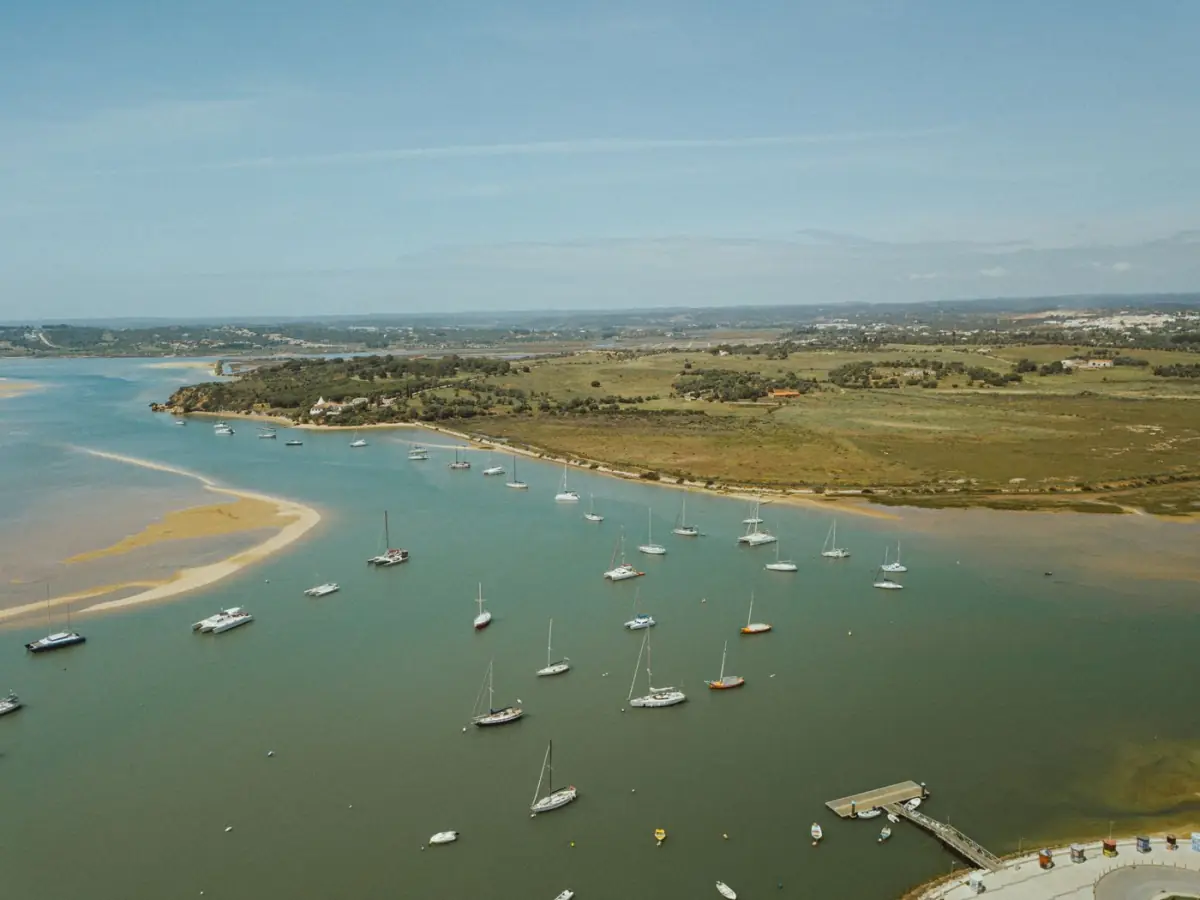 Vista aérea de barcos coloridos na ria de Alvor junto ao sapal