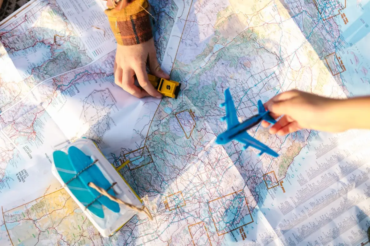 Avião e carro de brincar pousados sobre um mapa, a representar o planeamento da viagem ao Algarve