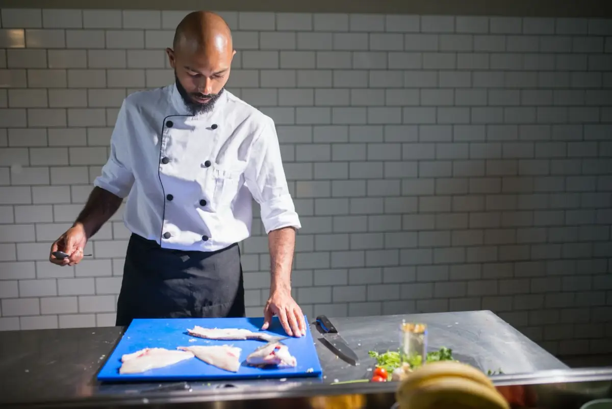 Chef a filetar peixe fresco na cozinha de um restaurante de alta cozinha no Triângulo Dourado