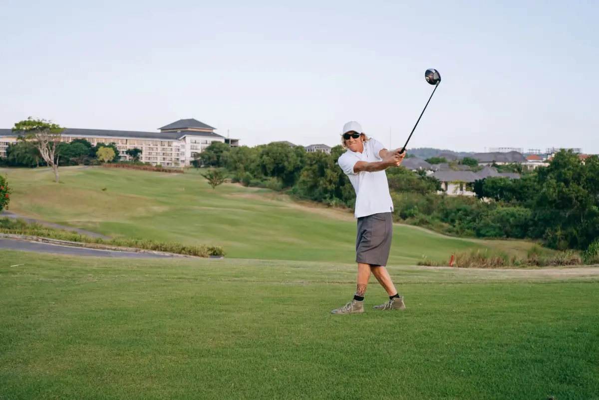 Golfista a executar o swing num campo de golfe relvado do Algarve