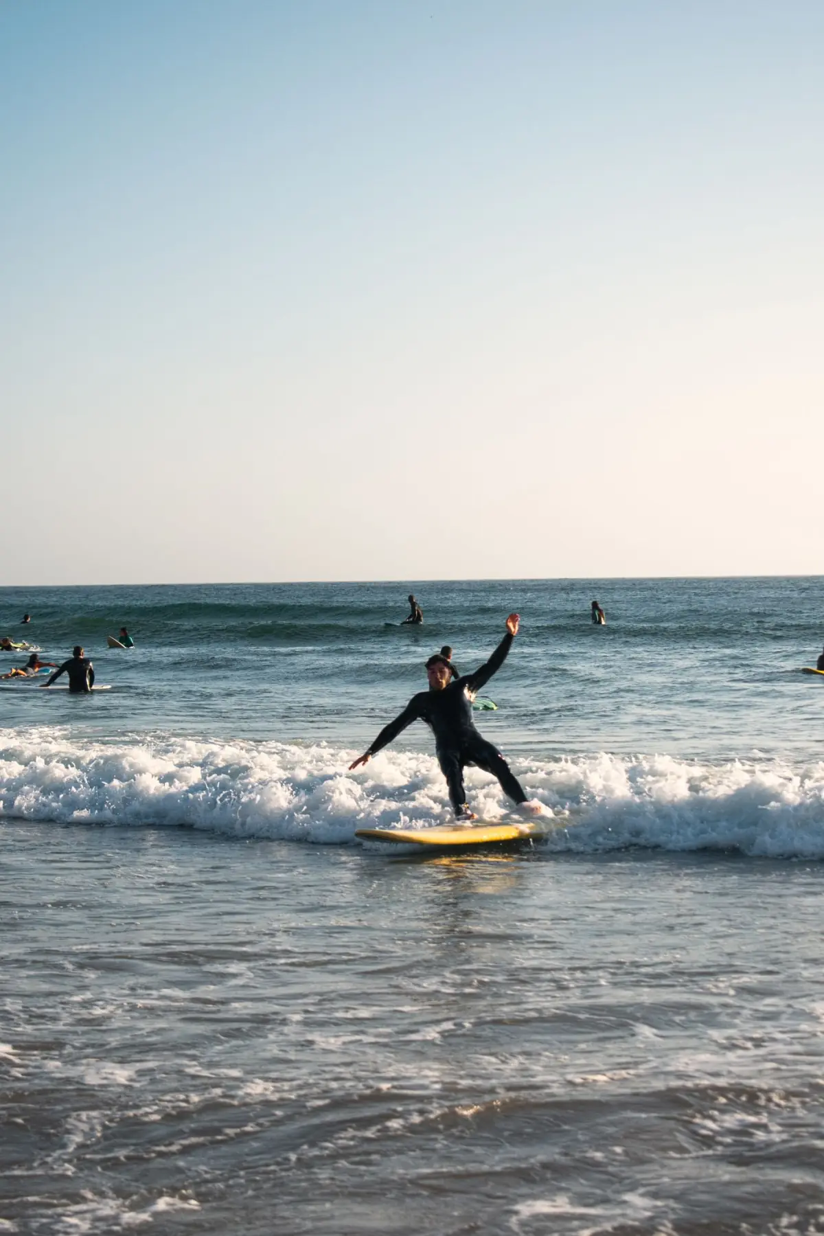Surfista a caminhar com a prancha num dia de sol numa praia de Aljezur, na Costa Vicentina